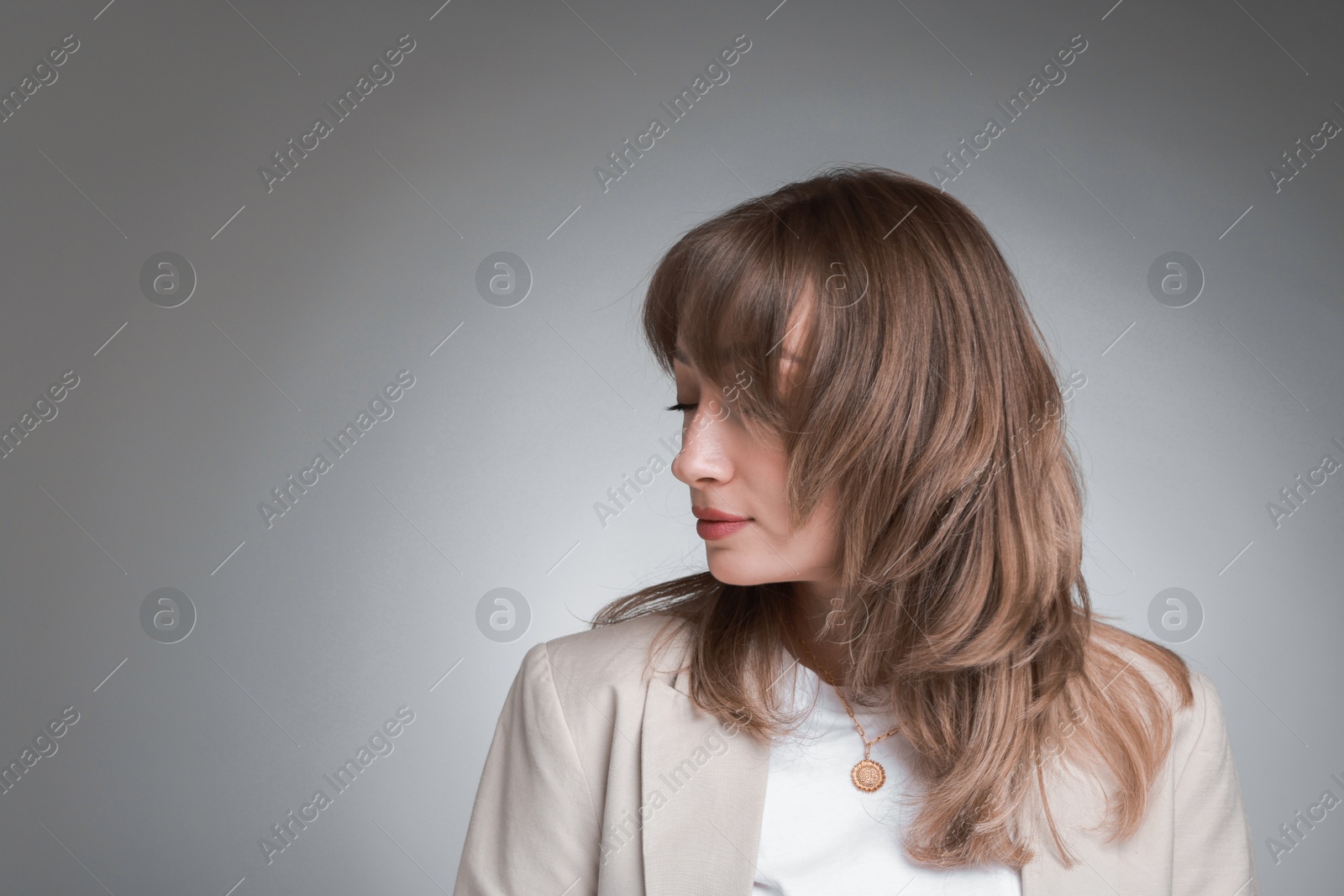 Photo of Attractive woman with stylish haircut on grey gradient background, space for text