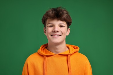 Photo of Portrait of happy teenage boy on green background