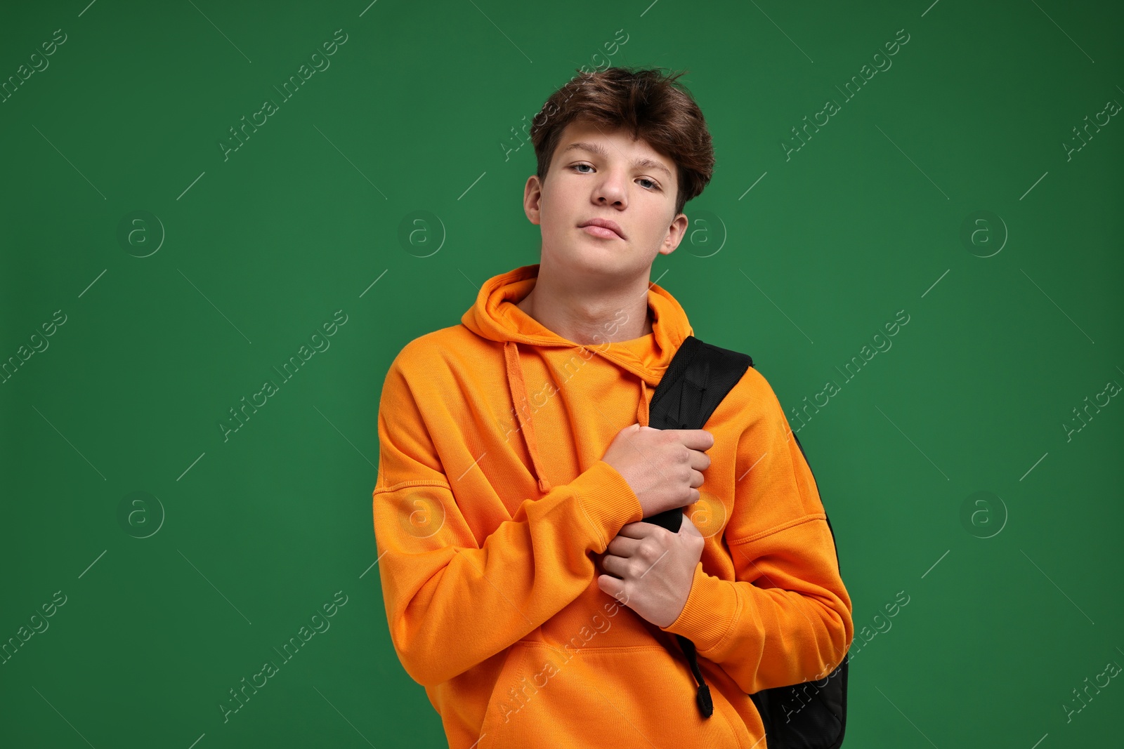 Photo of Teenage boy with backpack on green background