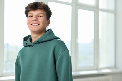 Photo of Portrait of happy teenage boy indoors, space for text