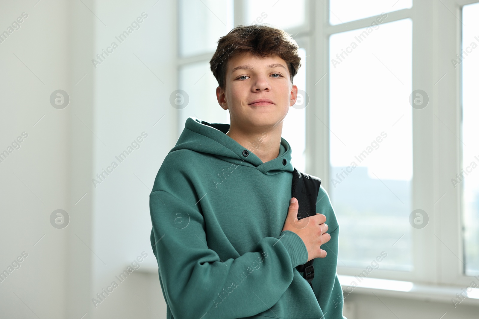 Photo of Portrait of teenage boy with backpack indoors