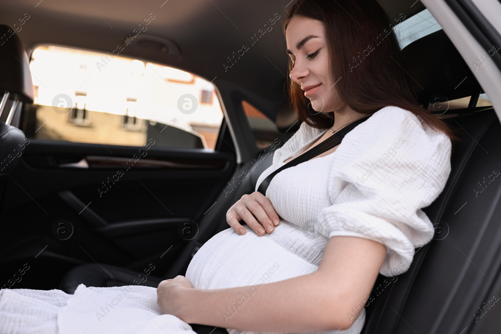 Photo of Pregnant woman with safety belt in car