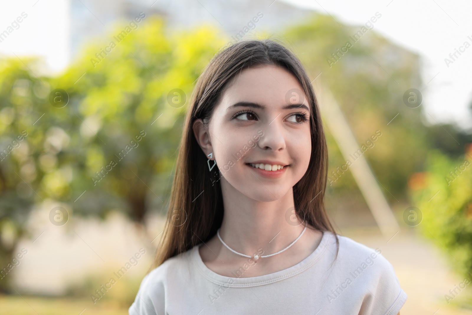 Photo of Portrait of smiling teenage girl on city street