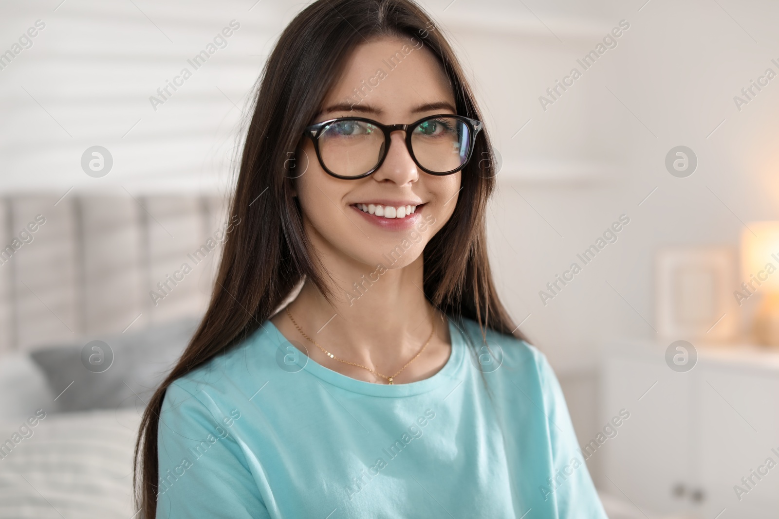 Photo of Portrait of happy teenage girl in glasses at home