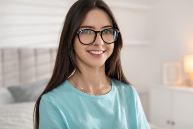 Photo of Portrait of happy teenage girl in glasses at home