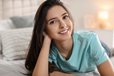 Photo of Portrait of smiling teenage girl on bed at home