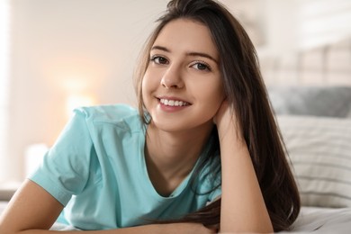 Photo of Portrait of smiling teenage girl on bed at home