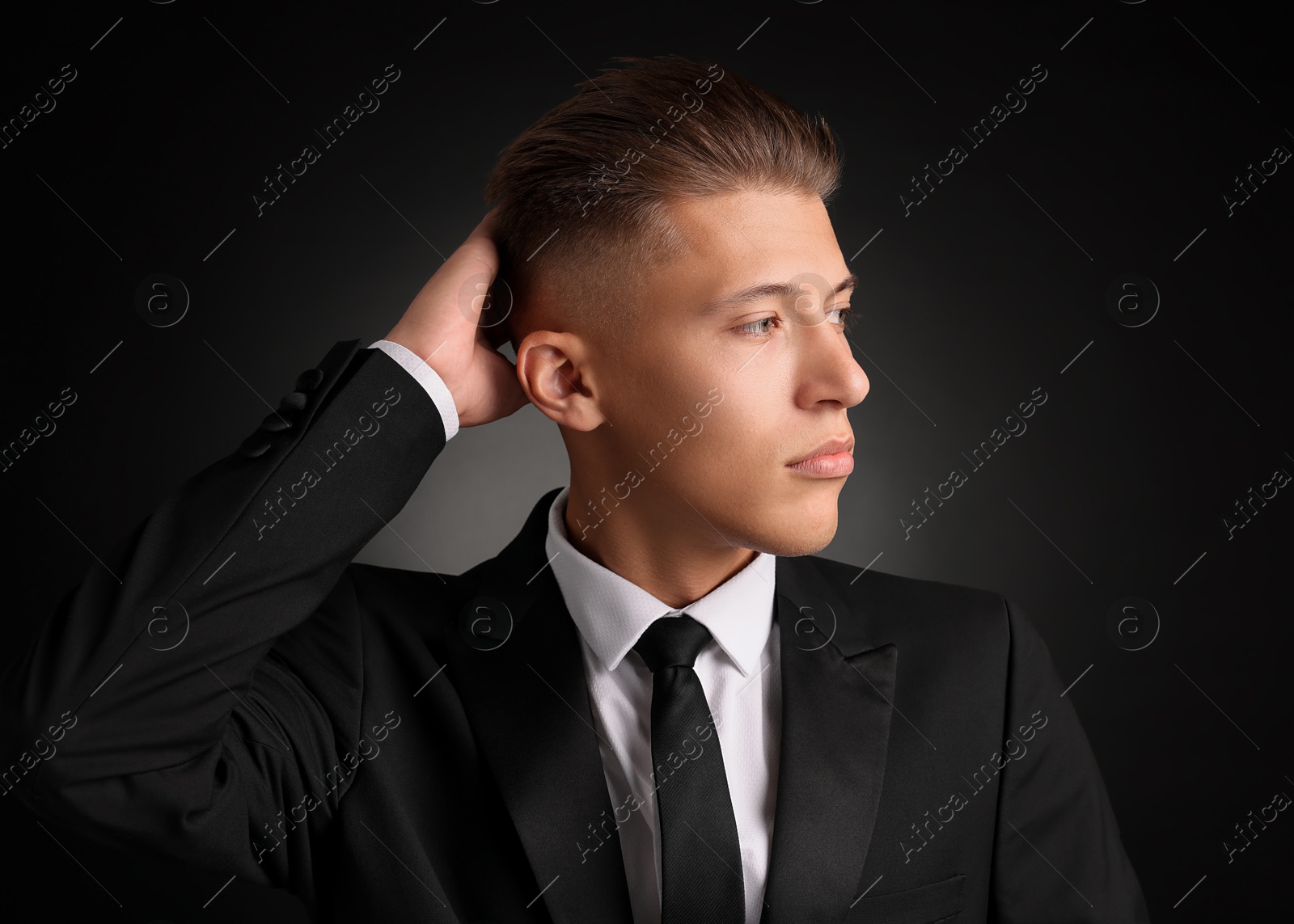 Photo of Confident young man with stylish haircut on black background