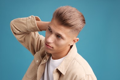 Photo of Confident young man with stylish haircut on blue background