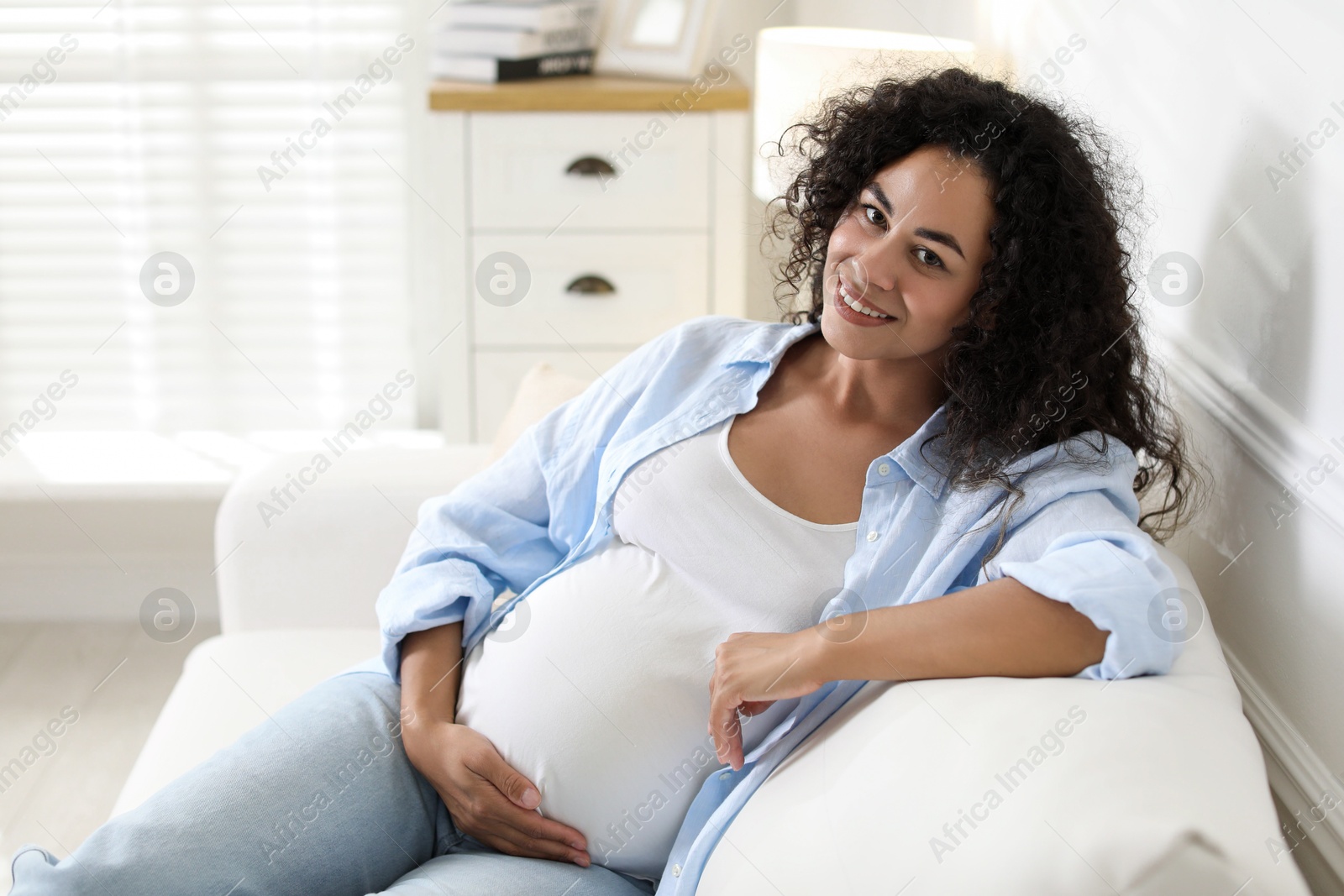 Photo of Portrait of beautiful pregnant woman on sofa at home