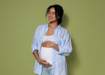 Photo of Portrait of beautiful pregnant woman on green background