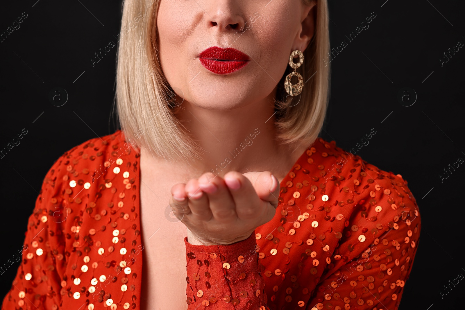 Photo of Woman sending air kiss on black background, closeup