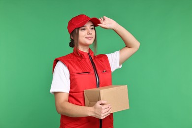 Photo of Girl in uniform with parcel on green background. Work for teenagers