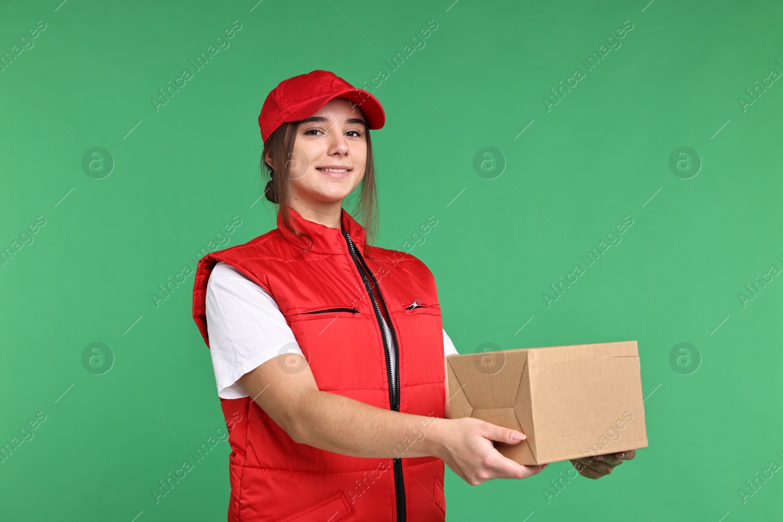 Photo of Girl in uniform with parcel on green background. Work for teenagers