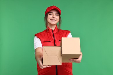 Photo of Girl in uniform with parcels on green background. Work for teenagers