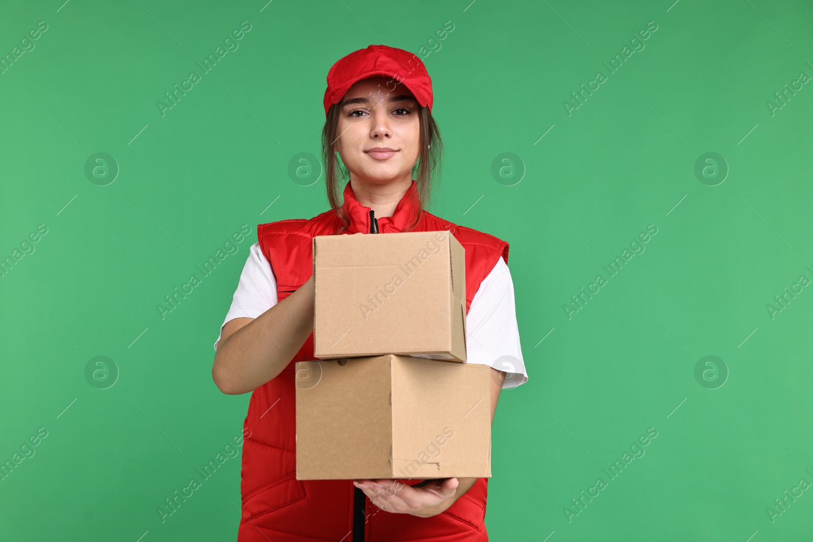 Photo of Girl in uniform with parcels on green background. Work for teenagers