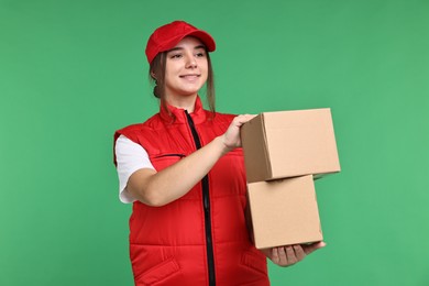 Photo of Girl in uniform with parcels on green background. Work for teenagers