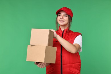 Photo of Girl in uniform with parcels on green background. Work for teenagers