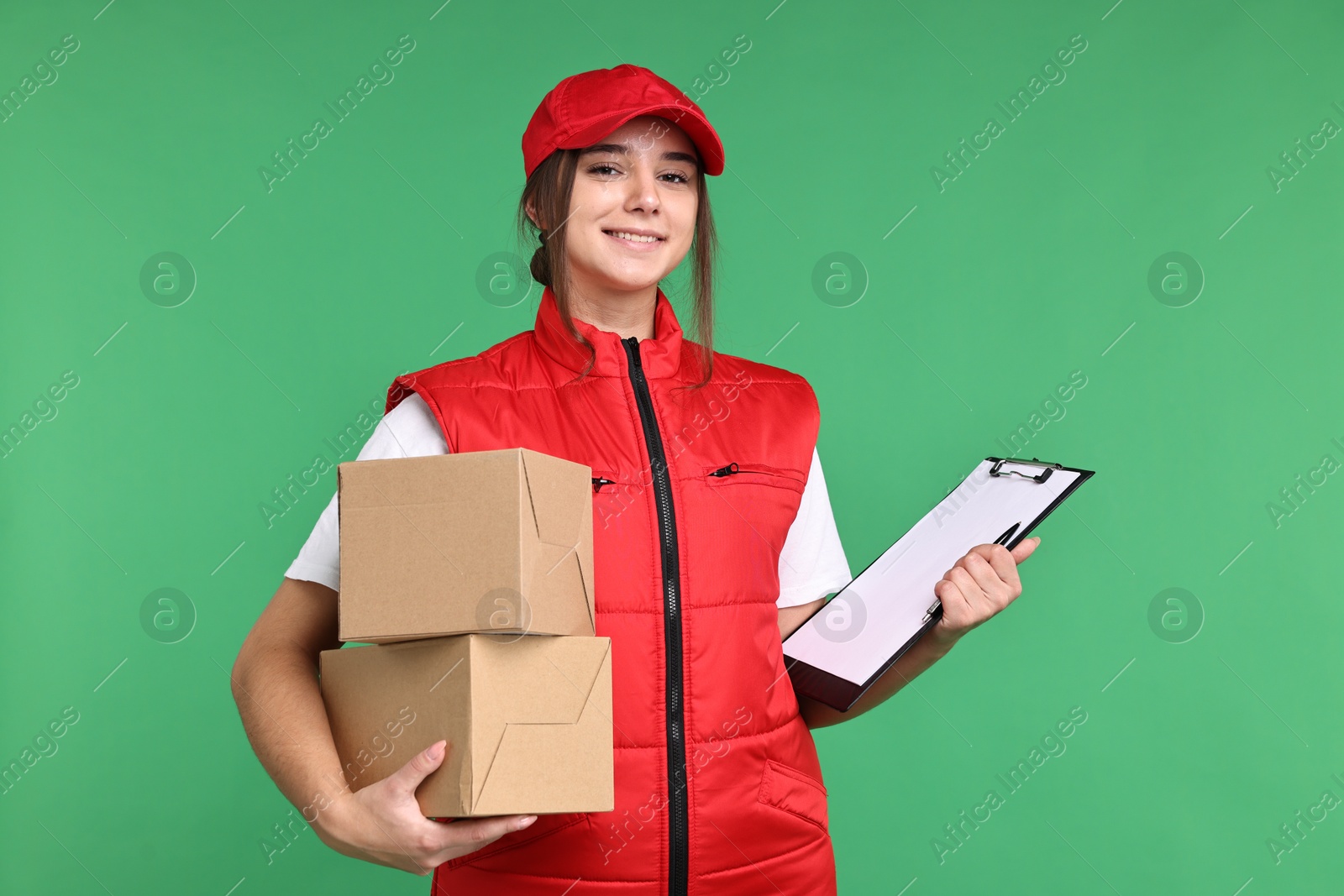 Photo of Girl in uniform with parcels and clipboard on green background. Work for teenagers