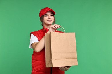 Photo of Girl in uniform with paper bag on green background. Work for teenagers