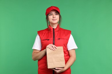 Photo of Girl in uniform with paper bag on green background. Work for teenagers