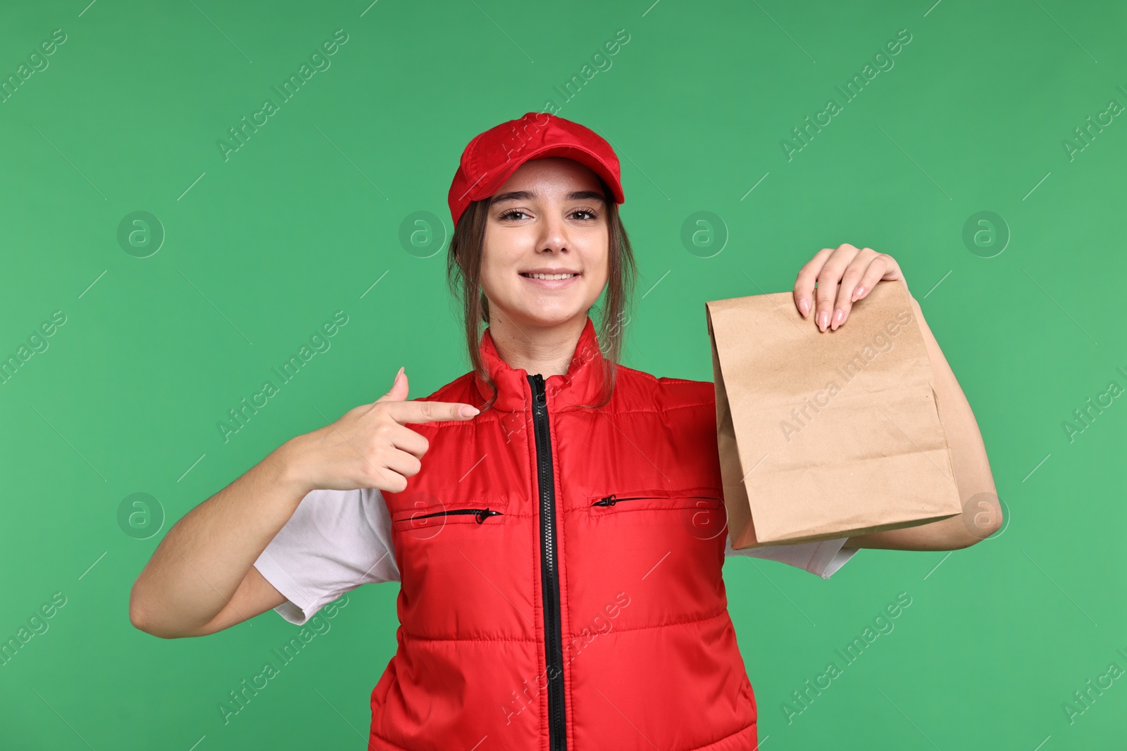 Photo of Girl in uniform with paper bag on green background. Work for teenagers