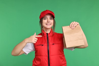 Photo of Girl in uniform with paper bag on green background. Work for teenagers