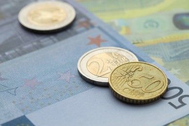 Photo of Different coins on euro banknotes, closeup view