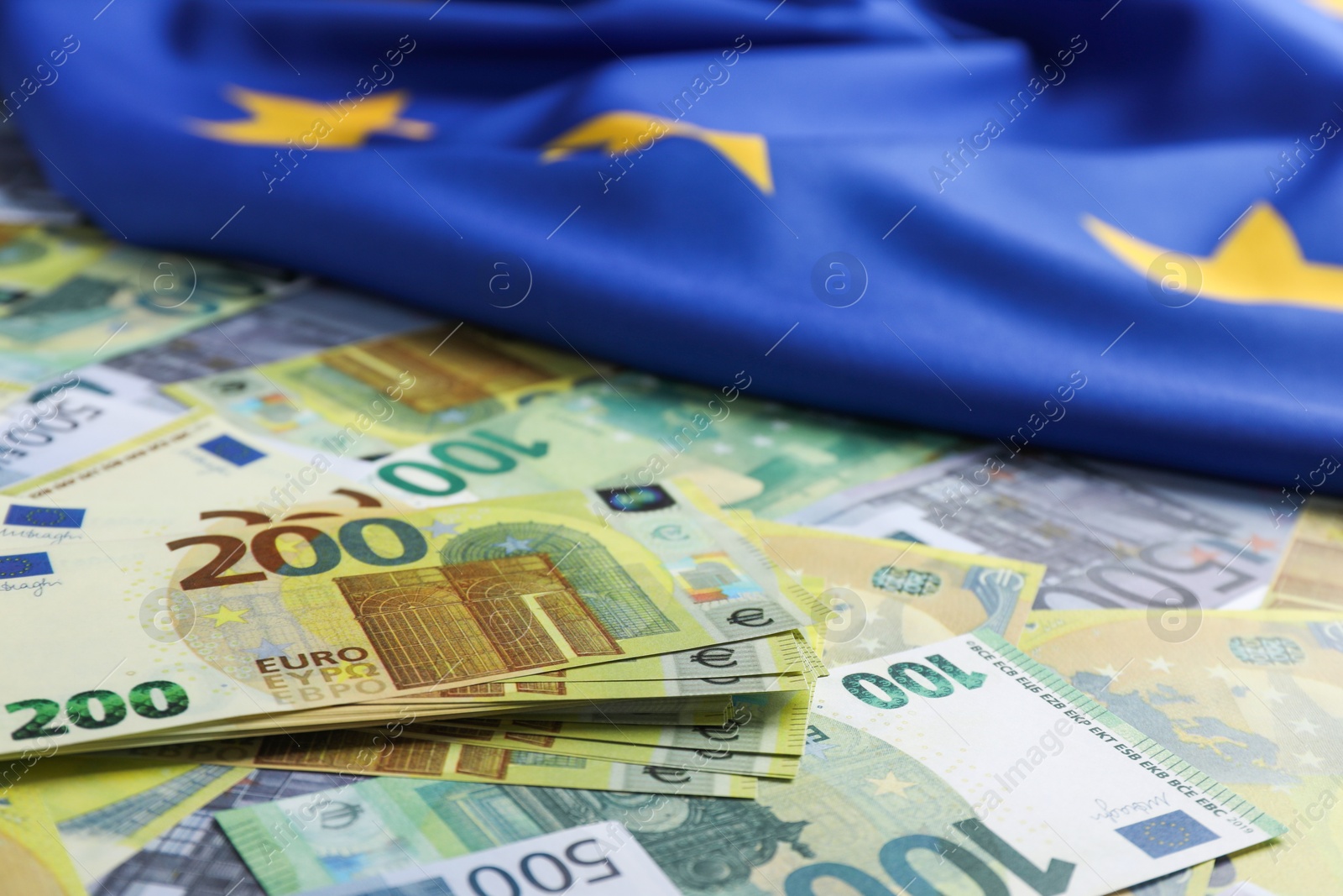 Photo of Euro banknotes and European Union flag, closeup