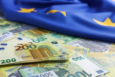 Photo of Euro banknotes and European Union flag, closeup