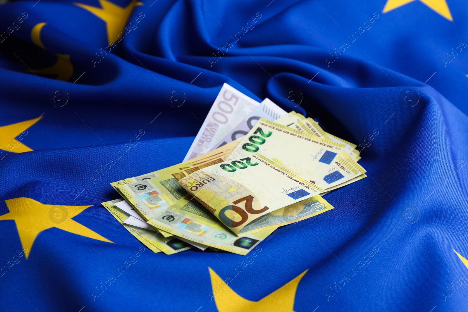 Photo of Euro banknotes on European Union flag, closeup