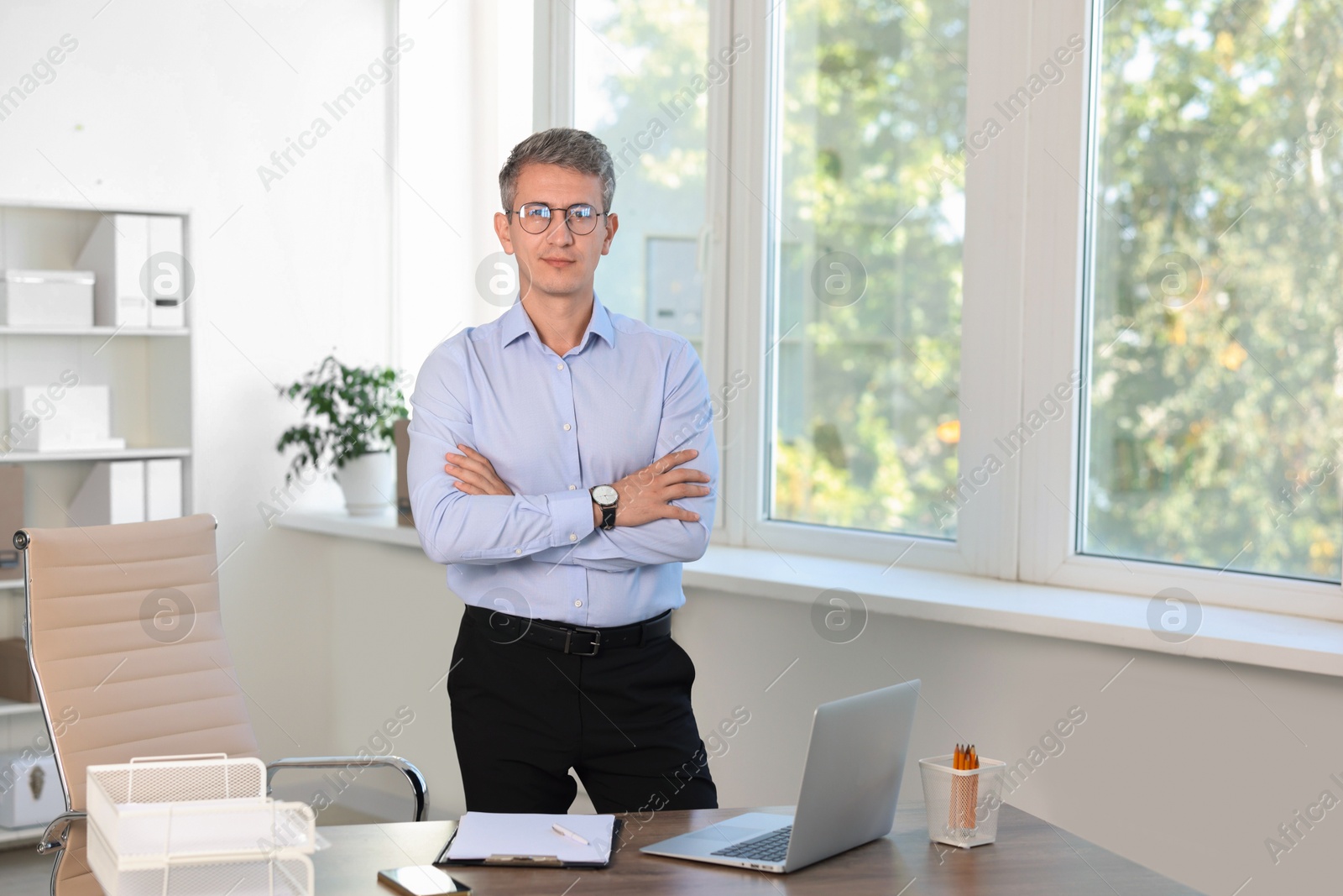 Photo of Portrait of middle aged man with crossed arms in office