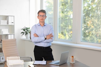 Portrait of middle aged man with crossed arms in office