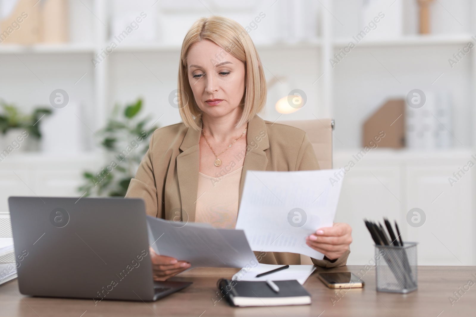 Photo of Middle aged woman working at table in office