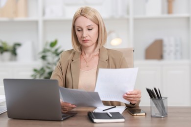 Middle aged woman working at table in office