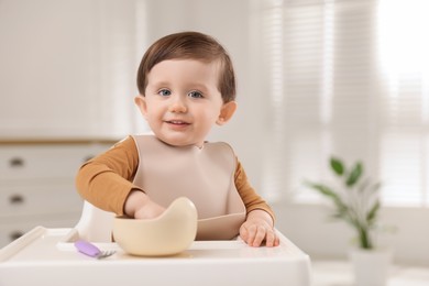 Photo of Cute little baby eating healthy food from bowl in high chair at home, space for text