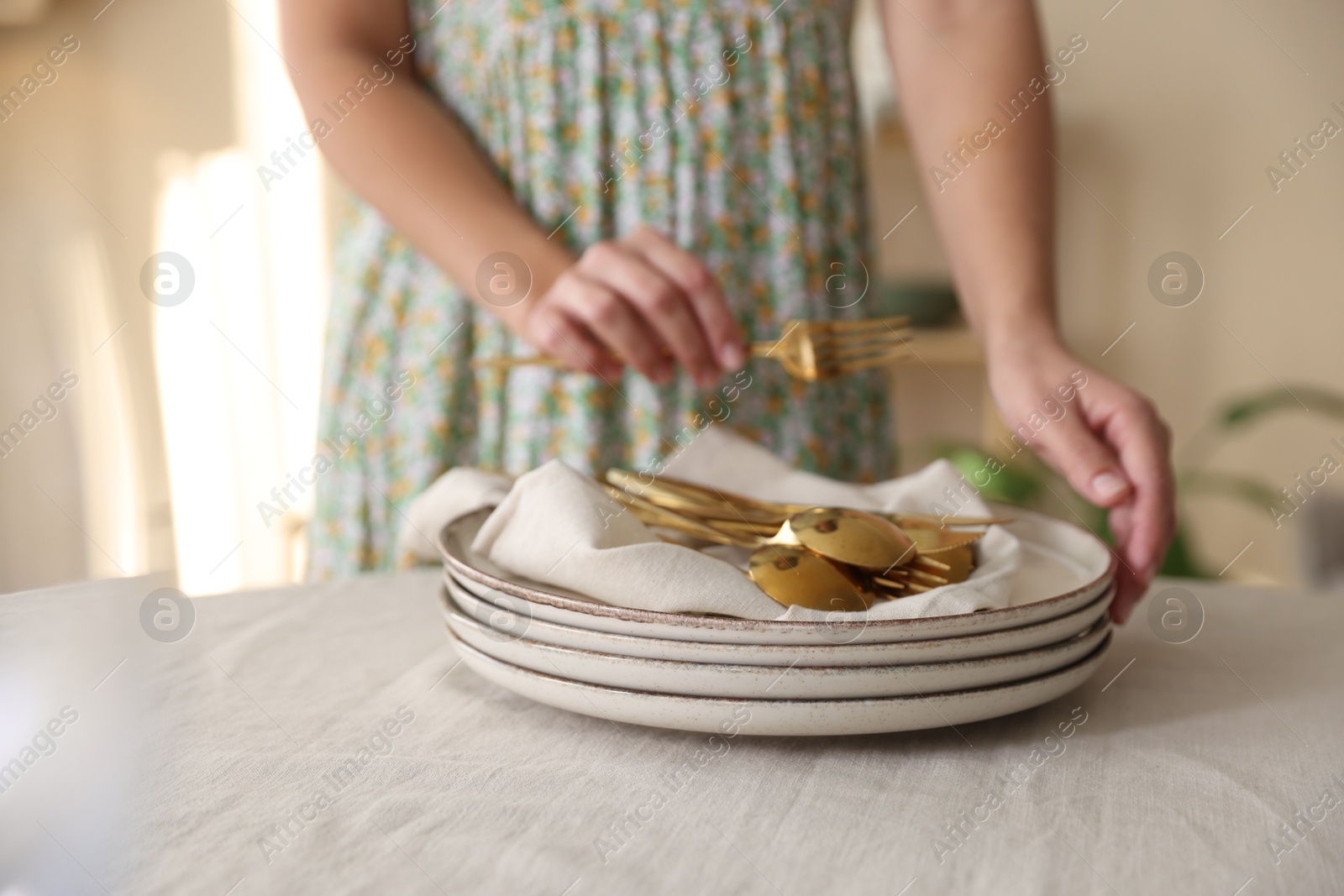 Photo of Woman setting table for dinner at home, closeup