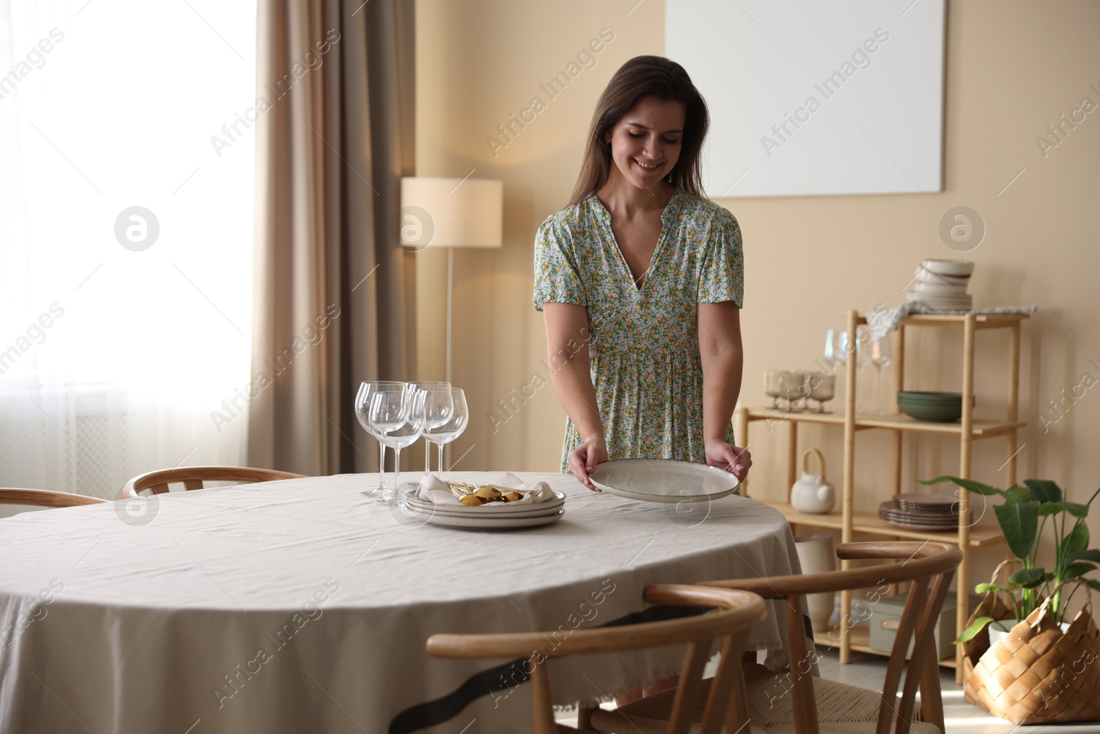 Photo of Woman setting table for dinner at home