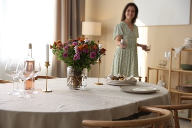 Photo of Woman setting table for dinner at home, selective focus