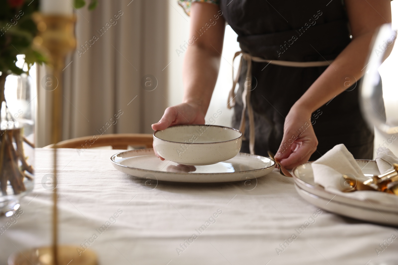 Photo of Woman setting table for dinner at home, closeup