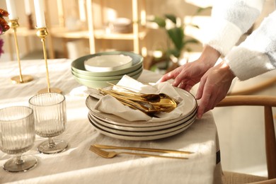 Photo of Woman setting table for dinner at home, closeup