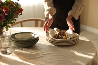 Photo of Woman setting table for dinner at home, closeup