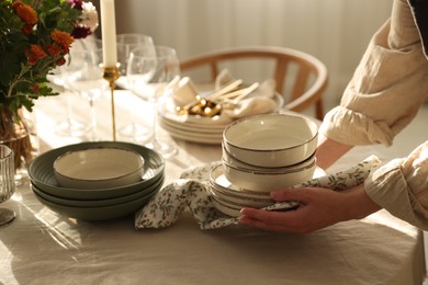 Photo of Woman setting table for dinner at home, closeup