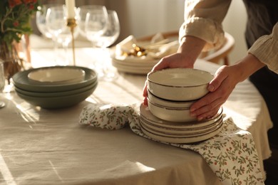 Photo of Woman setting table for dinner at home, closeup