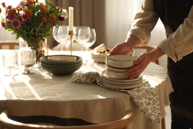 Photo of Woman setting table for dinner at home, closeup