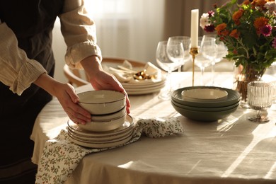 Photo of Woman setting table for dinner at home, closeup