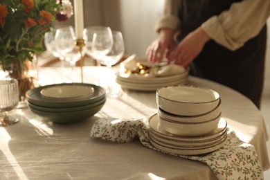 Photo of Woman setting table for dinner at home, closeup