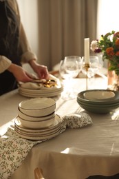 Photo of Woman setting table for dinner at home, closeup