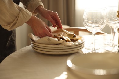 Photo of Woman setting table for dinner at home, closeup