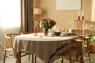 Photo of Stylish table setting with dishware, glasses and beautiful flowers indoors